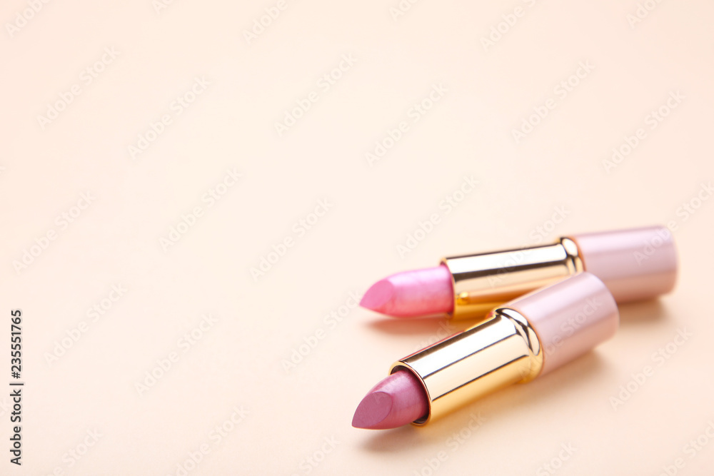 Two lipsticks on beige background, close up Two lipsticks on beige background, close up