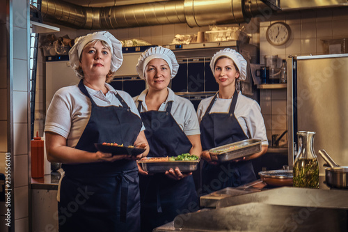 Cooking team posing for a camera at restaurant's kitchen. © Fxquadro