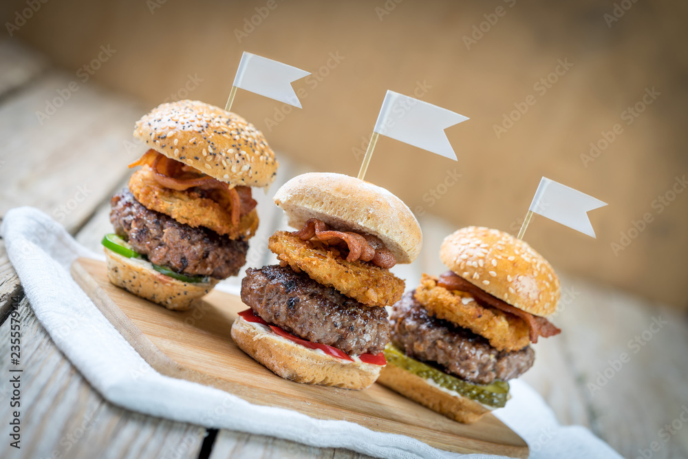 three selection of beef patty mini sliders burger sharing flags onions bacon cool