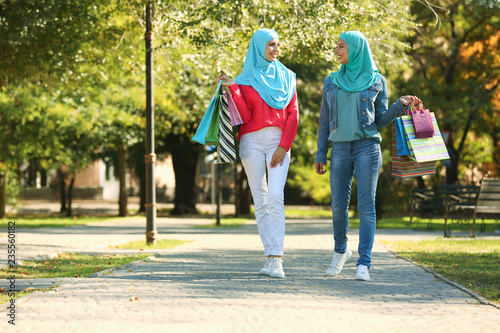 Muslim women with shopping bags walking in park © New Africa