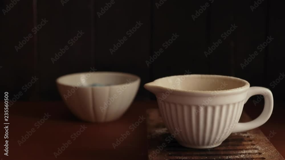 Sifting flour inside a white ceramic bowl during the making of a christmas cake Sifting flour inside a white ceramic bowl during the making of a christmas cake