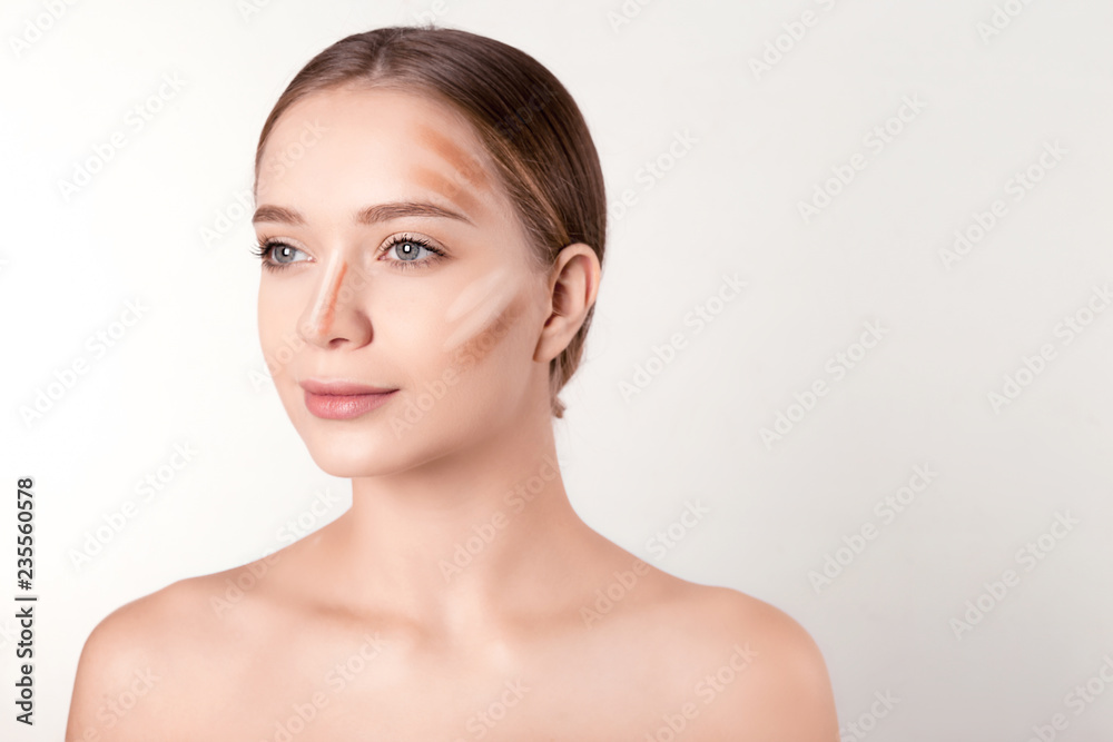 Portrait of beautiful young woman with makeup contouring smears on face against white background Portrait of beautiful young woman with makeup contouring smears on face against white background