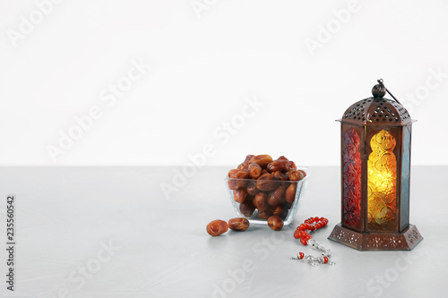 Muslim lamp, dates and prayer beads on table against white background. Space for text