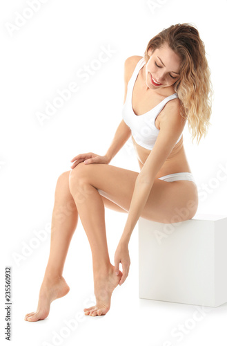 Young woman with beautiful long legs on white background