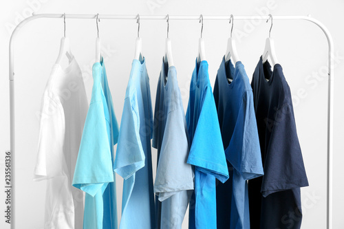 Men s clothes hanging on wardrobe rack against white background