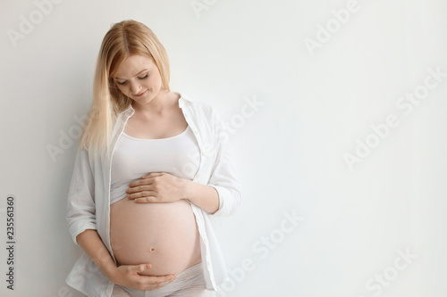Free Download Portrait of beautiful pregnant woman on light background. Space for text - GFXLoad