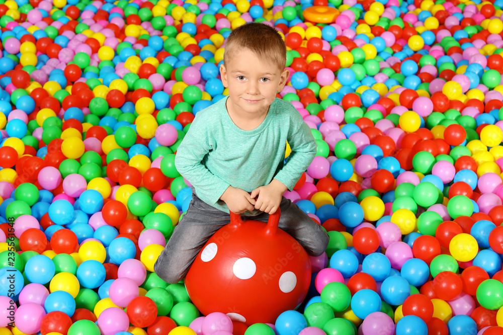 Obraz premium Cute child playing in ball pit indoors
