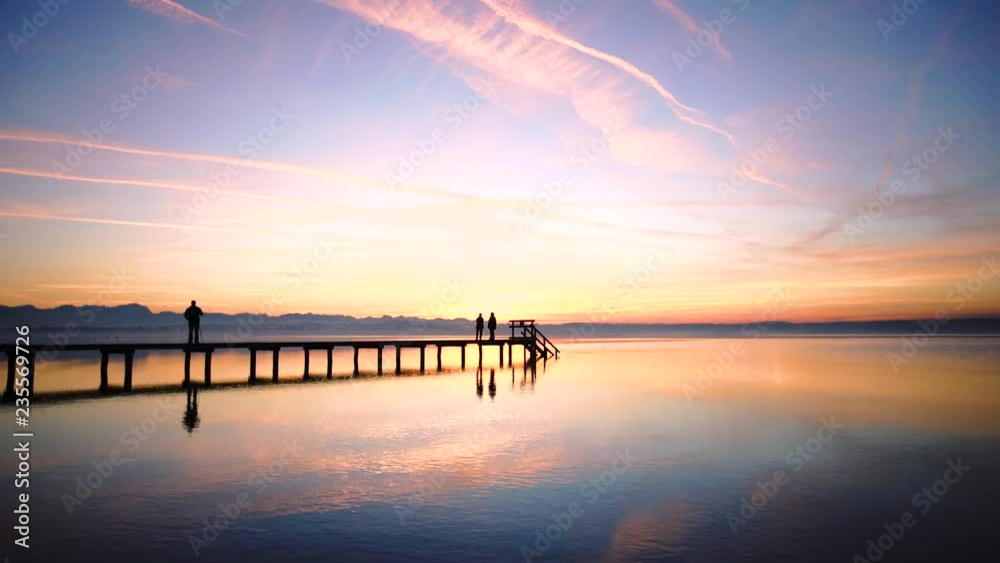 People siluete watch the sunset on the Lake Starnberg in Bavaria, Germany. People siluete watch the sunset on the Lake Starnberg in Bavaria, Germany.