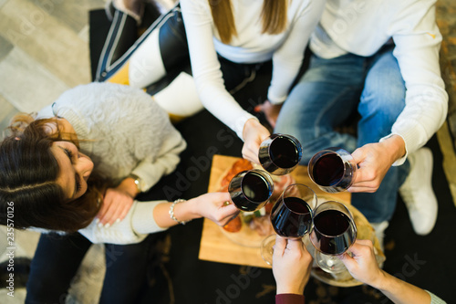 group of friends celebrating at home with glasses of wine