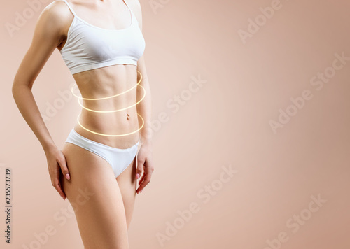 Slim woman body with glowing circles shows lifting effect. photo