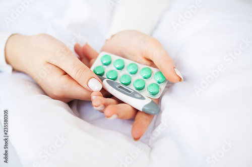 High temperature. Close up sick woman hold in her hand pill