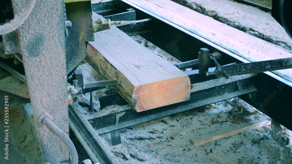 Sawmill. Process of machining logs in equipment sawmill machine saw saws the tree trunk on the plank boards. Wood sawdust work sawing timber wood wooden woodworking Sawmill. Process of machining logs in equipment sawmill machine saw saws the tree trunk on the plank boards. Wood sawdust work sawing timber wood wooden woodworking