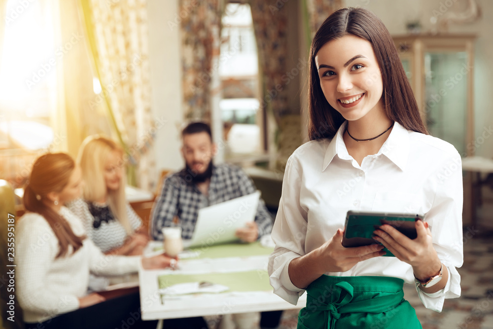 Portrait smiling young waitress standing in cafe