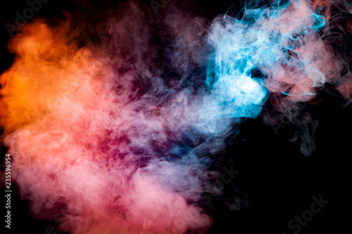 A background of blue, red and orange wavy smoke in the shape of a ghost's head or a man of mystical appearance on a black isolated ground. Bright abstract pattern of steam from vape.