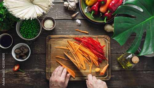 Male hands prepare vegetarian thai noodles table home kitchen top view photo