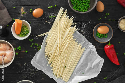 Raw ingredients cooking udon noodles chicken meat dark wooden table top view photo