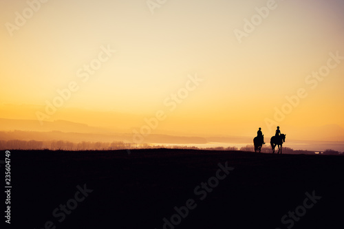 Two Horse Riders on Silhouetted on Sunset Field  Beautiful Peaceful Sport Landscape