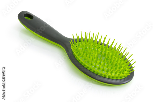Hairbrush with green plastic bristles on a white background
