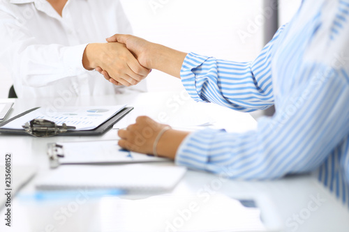 Business handshake at meeting or negotiation in office. Partners shaking hands while satisfied because signing contract or financial papers. Best client service, casual style. Success concept
