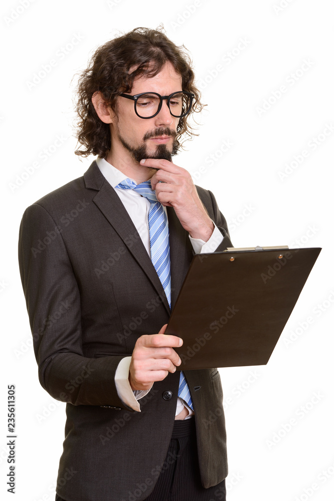 Handsome Caucasian businessman reading clipboard while thinking Handsome Caucasian businessman reading clipboard while thinking