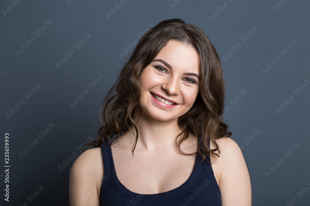 Beautiful young girl on a gray background smiling Beautiful young girl on a gray background smiling