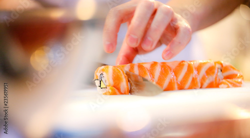 Obraz na plátně chef hands preparing japanese food, chef making sushi, Preparing Sushi roll