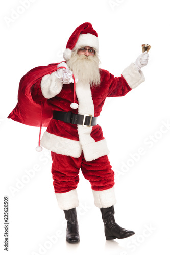 happy santa sings christmas carol while holding bag of presents