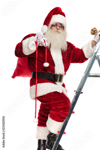 santa steps up the ladder to bring presents for christmas