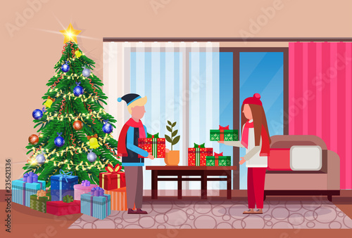 merry christmas happy new year couple give each other present gift box in living room pine tree home interior decoration winter holiday concept flat horizontal