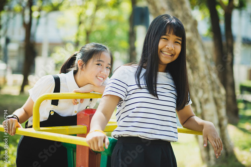 toothy smiling face of asian teenager relaxing in children playground