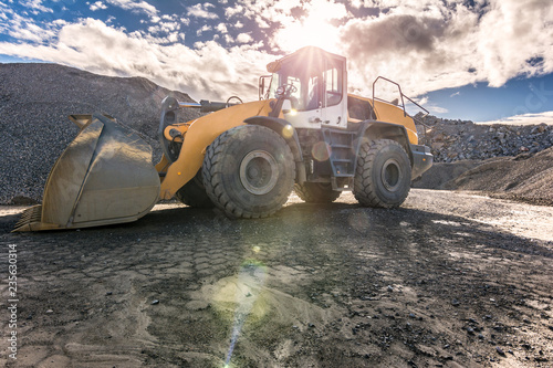 Excavator transporting stone for its transformation into gravel for the construction of a road