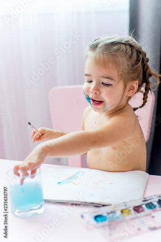 cute little girl is painting at home
