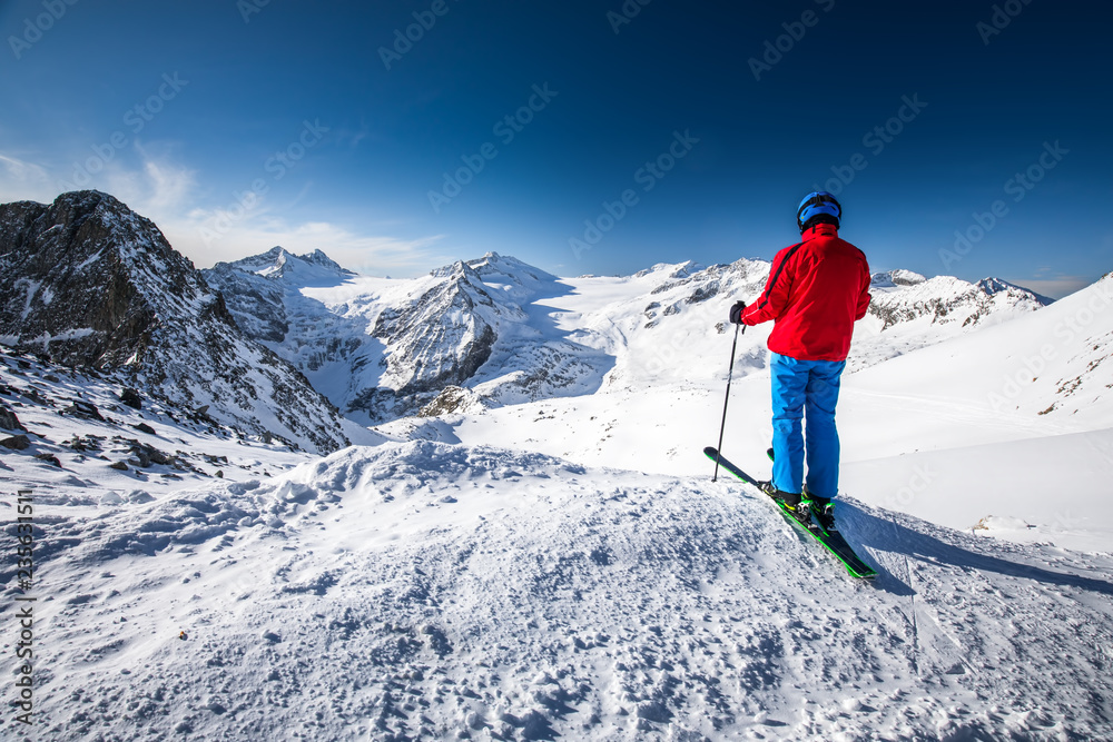 Young happy attractive skier on the top of mountains enjoying the view from Presena Glacier, Tonale, Italy