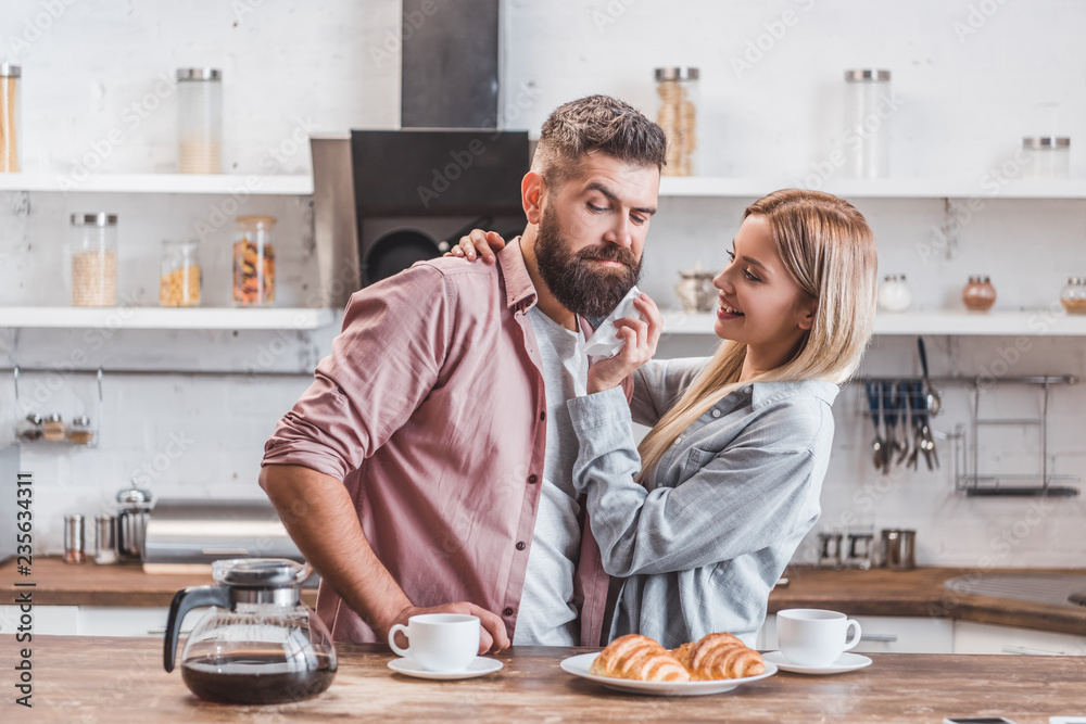 attractive young couple having breakfast together at kitchen