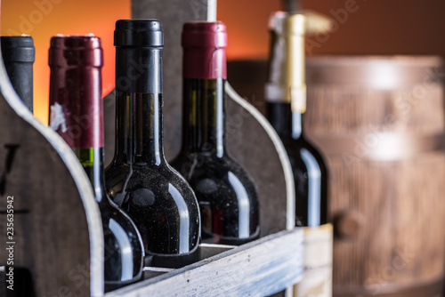 Wine bottles in wooden crate and oak wine keg.