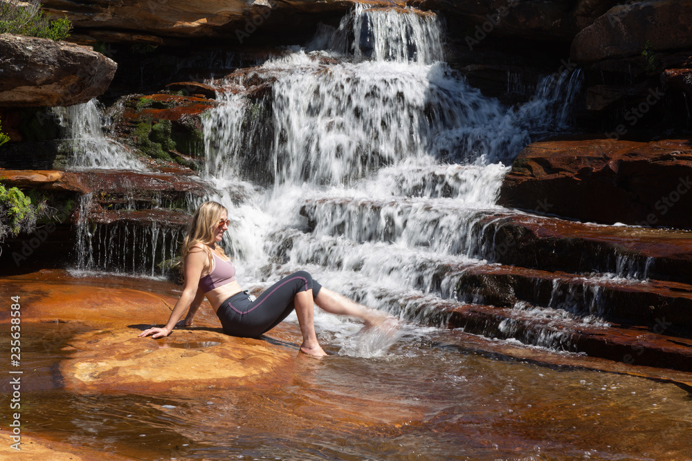 Female splashing her feet in cascading waterfall Female splashing her feet in cascading waterfall