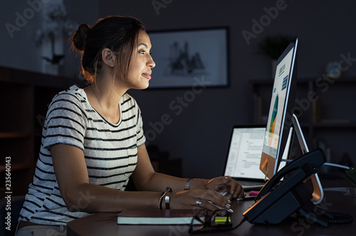 Casual woman working late at computer