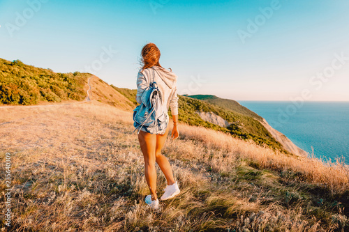 Happy sporty woman in nature at warm sunset. Holidays in the mountains