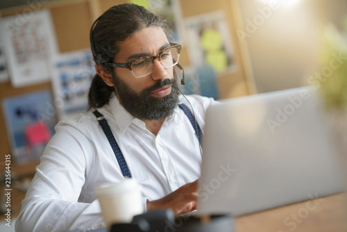 Trendy guy working in office on laptop