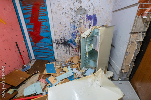 Old fridge killed by a sledgehammer in the ruins of an apartment