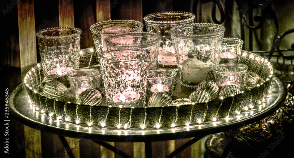 detail view of a decorative and festive Christmas holiday arrangement with glasses and candles and assorted decorative articles at night detail view of a decorative and festive Christmas holiday arrangement with glasses and candles and assorted decorative articles at night