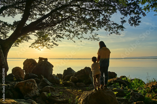 Mother and son watching sunset on the lake   Thailand