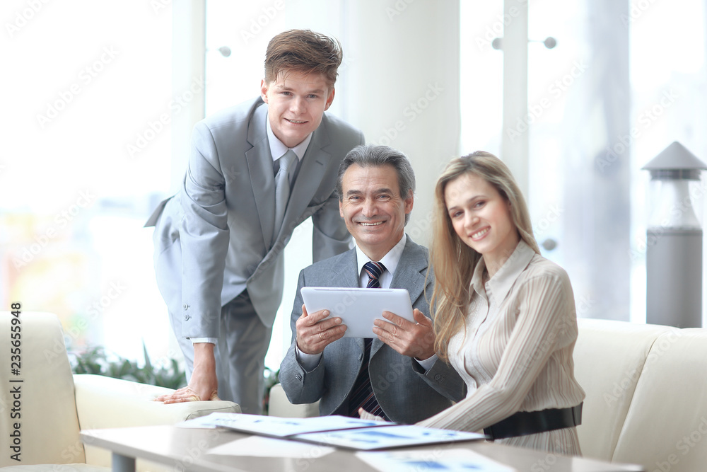 businessman and his colleagues sitting at the table in the office businessman and his colleagues sitting at the table in the office