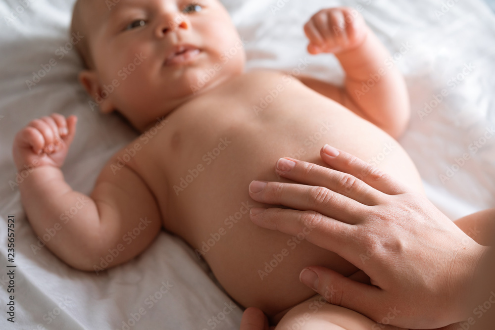 Mother doing tummy massage to newborn baby. Mom massaging infant belly, baby  smiling. Treatment of colic Stock Photo | Adobe Stock