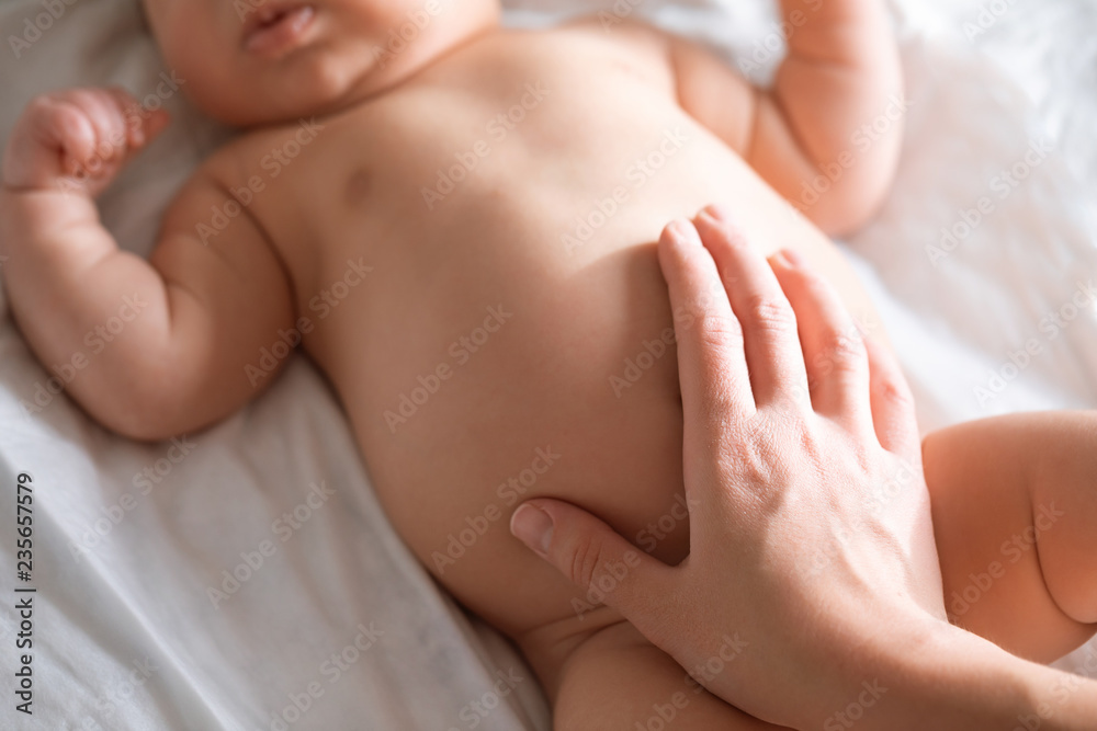 Massage stomach for little newborn baby. Mom massaging colic tummy of newborn. Healthy motherhood. Massage stomach for little newborn baby. Mom massaging colic tummy of newborn. Healthy motherhood.