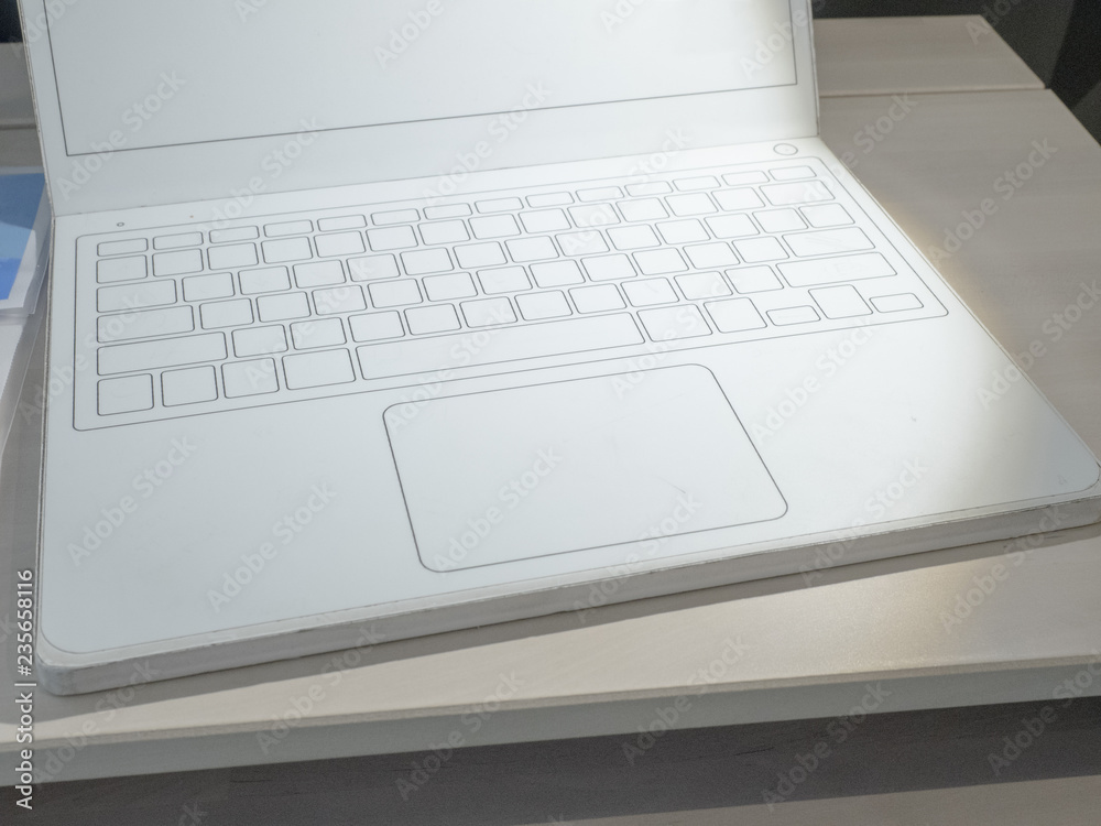 Front view of a modern laptop with a white screen and an empty white keyboard on a table. Front view of a modern laptop with a white screen and an empty white keyboard on a table.