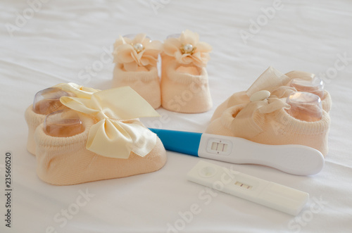Pregnancy test and baby shoes. Ready to have children