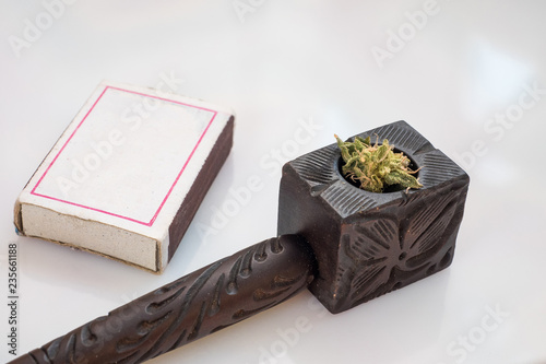 Wooden tobacco pipe and matches on white background, hemp for smoking. smoke marijuana. Cannabis Smoking Pipe. © Evgeniy