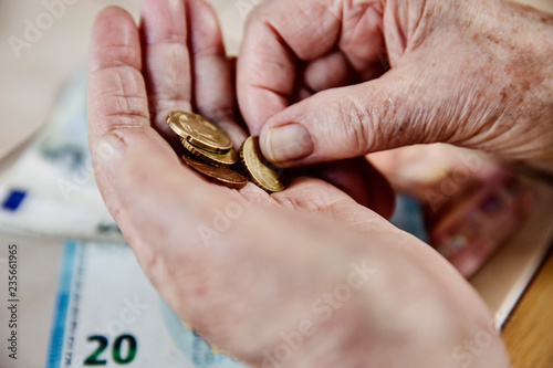 Hand einer Seniorin mit Bargeld, Seniorin zählt ihr Geld