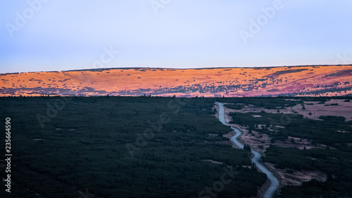 View from the mountain Snezka hillside on the hiking trail hiding on the horizon in the early morning during sunrise